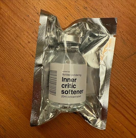 A 20ml vial labeled 'Inner Critic Softener,' part of the Bottled Pondering exhibit by Aepenton at the Design Museum Denmark, sealed in reflective foil packaging.