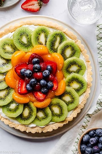 overhead image of fresh fruit tart with glass of sparkling water.