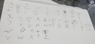 alphabet letters and pictograms drawn in pencil by a child