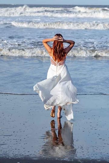 Current image: woman in white dress by the ocean shore
