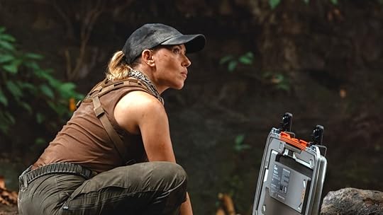 Scarlett Johansson in a baseball cap kneeling down in the jungle in Jurassic World Rebirth