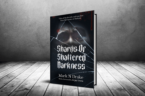An image of a book standing in a bare room. The cover shows terrified eyes almost lost in shadow, gazing though cracked glass. The cover reads “Shards of Shattered Darkness. Tales of the horrific and macabre from the creator of Darkisle. Mark N Drake. With a foreword by Arjay Lewis.”