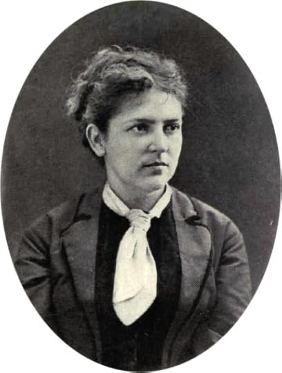 Oval-framed black and white portrait of a woman with wavy hair pulled back, wearing a dark jacket over a light blouse with a large white scarf tied at the neck, looking slightly to her left with a serious expression.