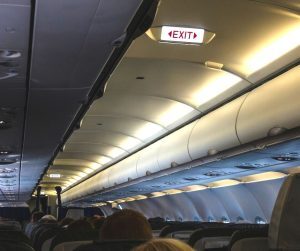 airplane showing exit row signs above seating
