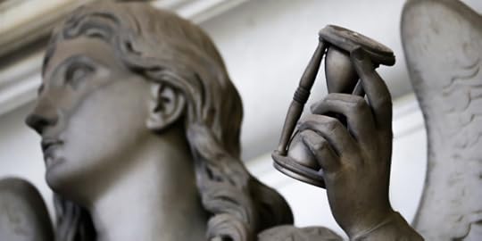 Statue of angle holding an hourglass in its hand (DepositPhoto)