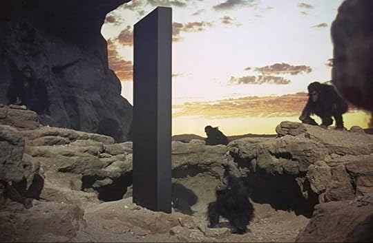 Pre-human apes approach a tall, black monolith in Stanley Kubrick's