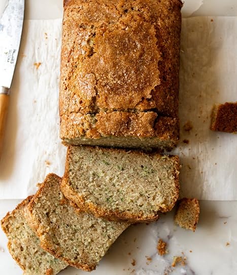 A sliced loaf of brown butter zucchini bread on parchment paper, showing the moist interior.
