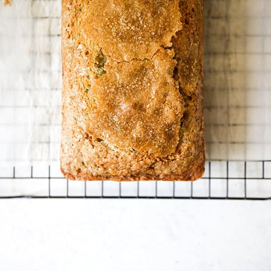 A freshly baked loaf of brown butter zucchini bread cooling on a wire rack, showing its golden-brown crust and sugar topping.