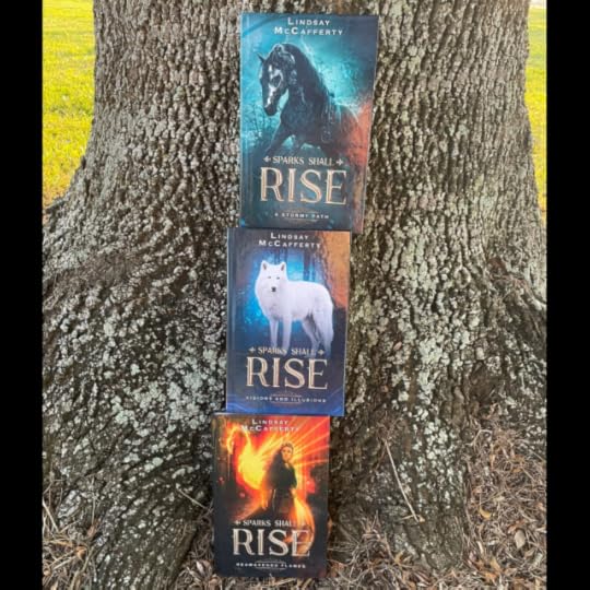 Three books stacked on top of each other against a tree