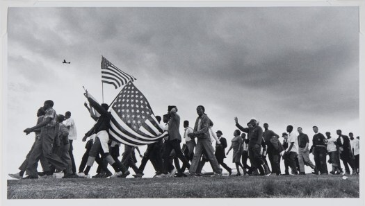 a line of marchers, some carrying American flags, in the Selma to Montgomery March of 1965