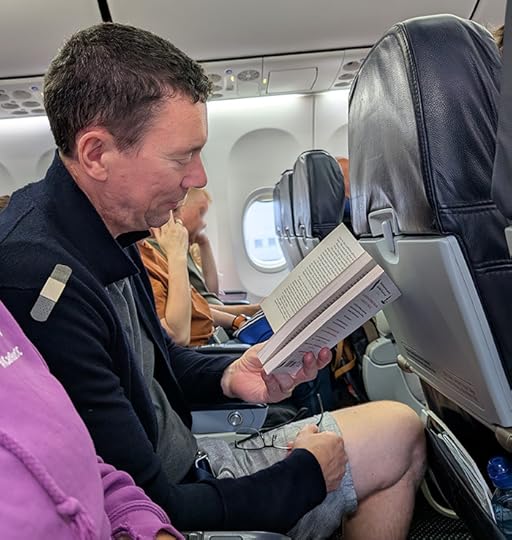 Author Stephen Henning reading Eight Detectives, a crime novel by Alex Pavesi, whilst on an aeroplane