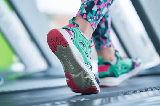 close up of feet in colorful athletic shoes walking on a treadmill