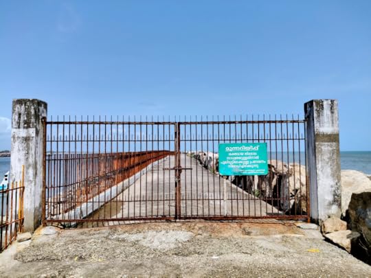 Thangasserry Breakwater Tourism Park. Closed gate with warning signs about strong sea waves.