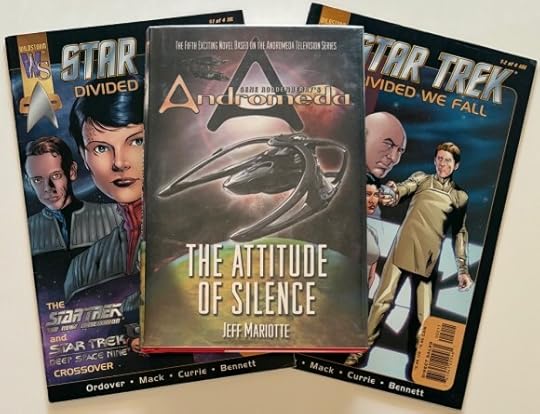Hardcover of Andromeda: The Attitude of Silence, sitting atop two copy books, issue 1 and 2 of Star Trek: Divided we Fall.