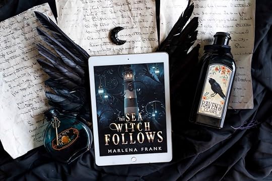 The book for The Sea Witch Follows by Marlena Frank lays on top of black wings with a tiny black crescent moon above. Beside it are two potion bottles, one that has a picture of a raven with flowers that says Raven’s claws. In the background are manuscript pages written in black ink but the words are illegible. The cover for The Sea Witch Follows is an image of a white and black lighthouse at night with a golden light emerging from the tower. Black swirls and blue lanterns surround it as it sits atop a rocky crag and sea water splashes around it.