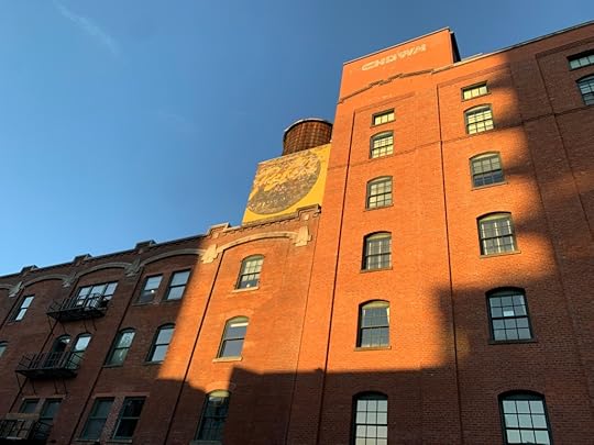 An old brick building with the sun shining on it and the word 