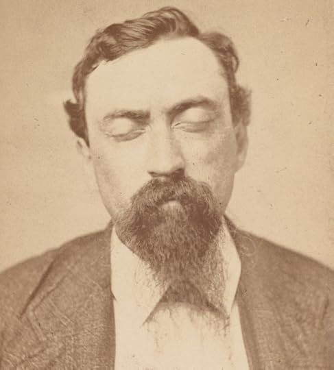 John Duffy, head-and-shoulders portrait, facing front, eyes closed. He has a thick moustache and beard and is wearing a white shirt buttoned to the collar and a dark suit jacket.