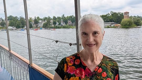 Jeanne Gehret on boat with Chatauqua Institute bell tower on shore