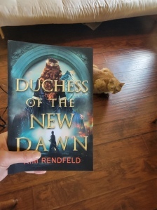 The paperback proof of Duchess of the New Dawn, with a cat in the background.