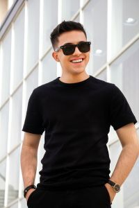 Smiling man in a black shirt wearing sun glasses