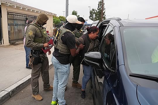 A woman is detained by U.S. Border Patrol agents outside...
