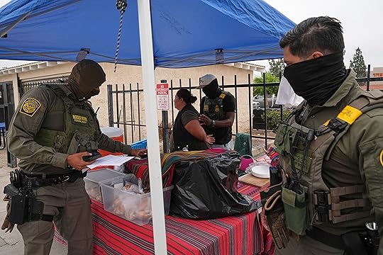 A woman is detained by U.S. Border Patrol agents outside...