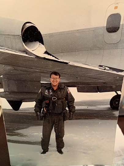Naval flight officer standing under the wing of a P-3 Orion