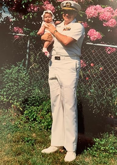 Navy officer in summer whites holding a baby