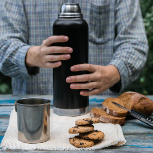 Thermos, cookies, and bread on a wooden table. (Image: DepositPhoto)