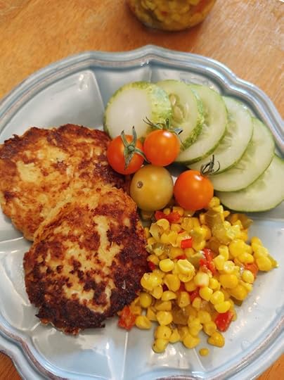 Corn relish on a plate with zucchini fritters and fresh cucumber slices and cherry tomatoes