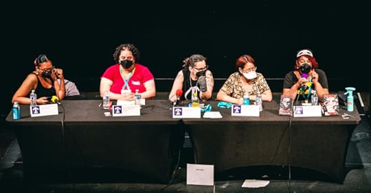 five BIPOC authors seated at a panel table with a black background