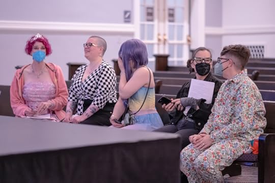 five mirthful looking writers on a church pew, chatting