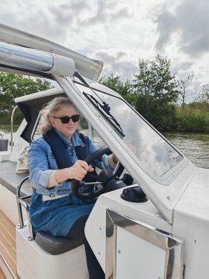 Debbie driving a boat on the Norfolk Broads
