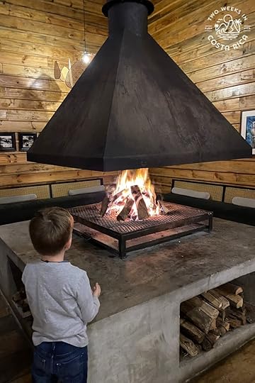 a kid standing next to a fireplace