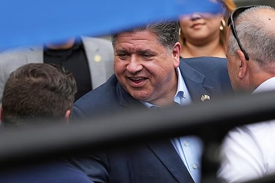 Illinois Governor JB Pritzker greets people as he walks to...