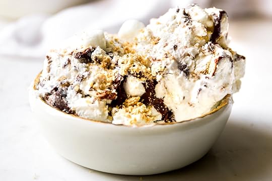 A generous scoop of no-churn s'mores ice cream in a small white bowl. The texture is visible with dark chocolate chunks, crushed graham cracker crumbs, and mini marshmallows mixed throughout.