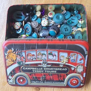 old shortbread tin with bus design holding buttons