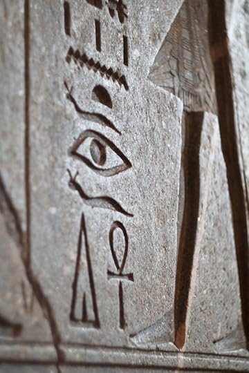 Close-up of Egyptian hieroglyphs engraved in stone, featuring ancient symbols like the Eye of Horus and Ankh, often associated with pineal gland frequencies.