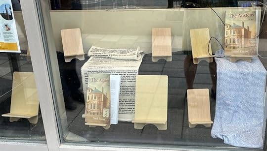 Window display with several empty book stands and two copies of The Austens