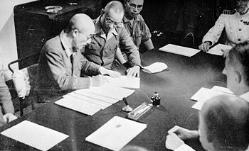 General Seishiro Itagaki signing surrender documents aboard HMS Sussex at Singapore, 4 Sep 1945 (Imperial War Museum: 4700-01 A 30481)