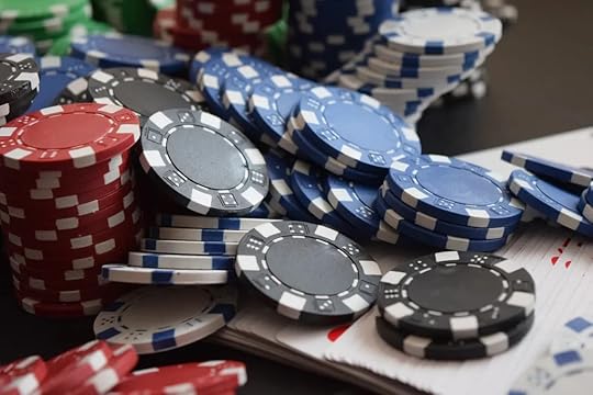 Stacks of red, blue, and black poker chips with playing cards