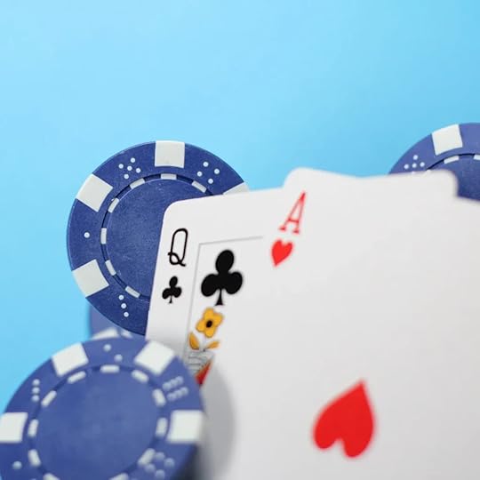 Blue poker chips and playing cards, including the Queen of Clubs and Ace of Hearts, against a blue background.