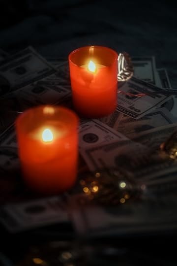 Red candles burning over stacks of dollar bills used in a spiritual money ritual for financial freedom affirmations