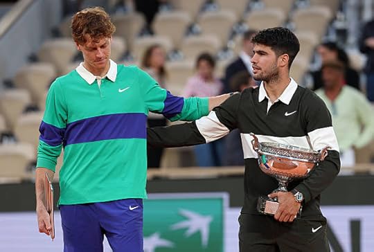 Carlos Alcaraz of Spain holds the Coupe des Mousquetaires trophy as he speaks with runner-up Jannik Sinner of Italy following his victory in the...