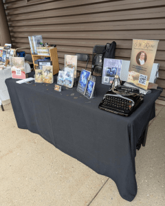 My comic con vendor checklist in action: table setup with books, banner, and steampunk props.