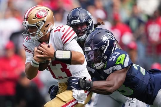 San Francisco 49ers quarterback Brock Purdy (13) tries to get past Seattle Seahawks linebacker Boye Mafe (53) during the first half of an NFL football game Sunday, Sept. 7, 2025, in Seattle. (AP Photo/Lindsey Wasson)