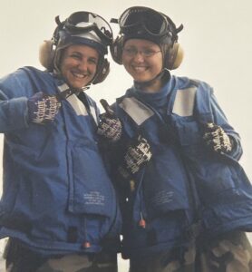 Two female U.S. Navy sailors wearing their blue shirt gear.