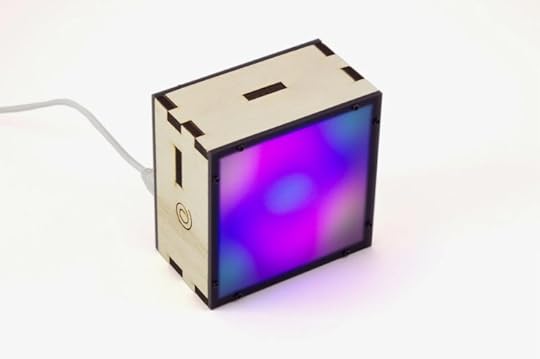 A square plywood box displays swirling, hypnotic colors on a clear, frosted face.