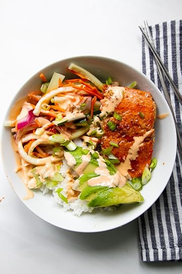 Assembled salmon rice bowl with pickled vegetables, spicy mayo, avocado, and green onions.