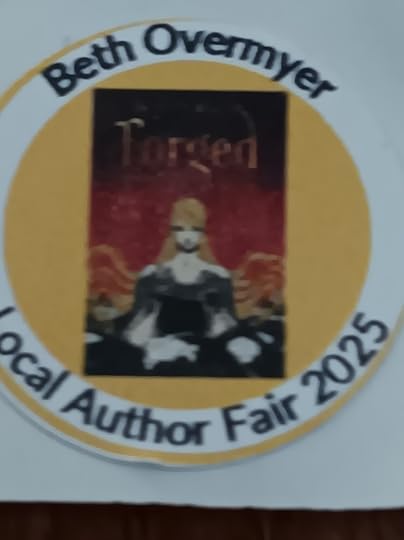 A close-up of a sticker featuring the cover for Forged. Surrounding the image is the text: Beth Overmyer Local Author Fair 2025/.